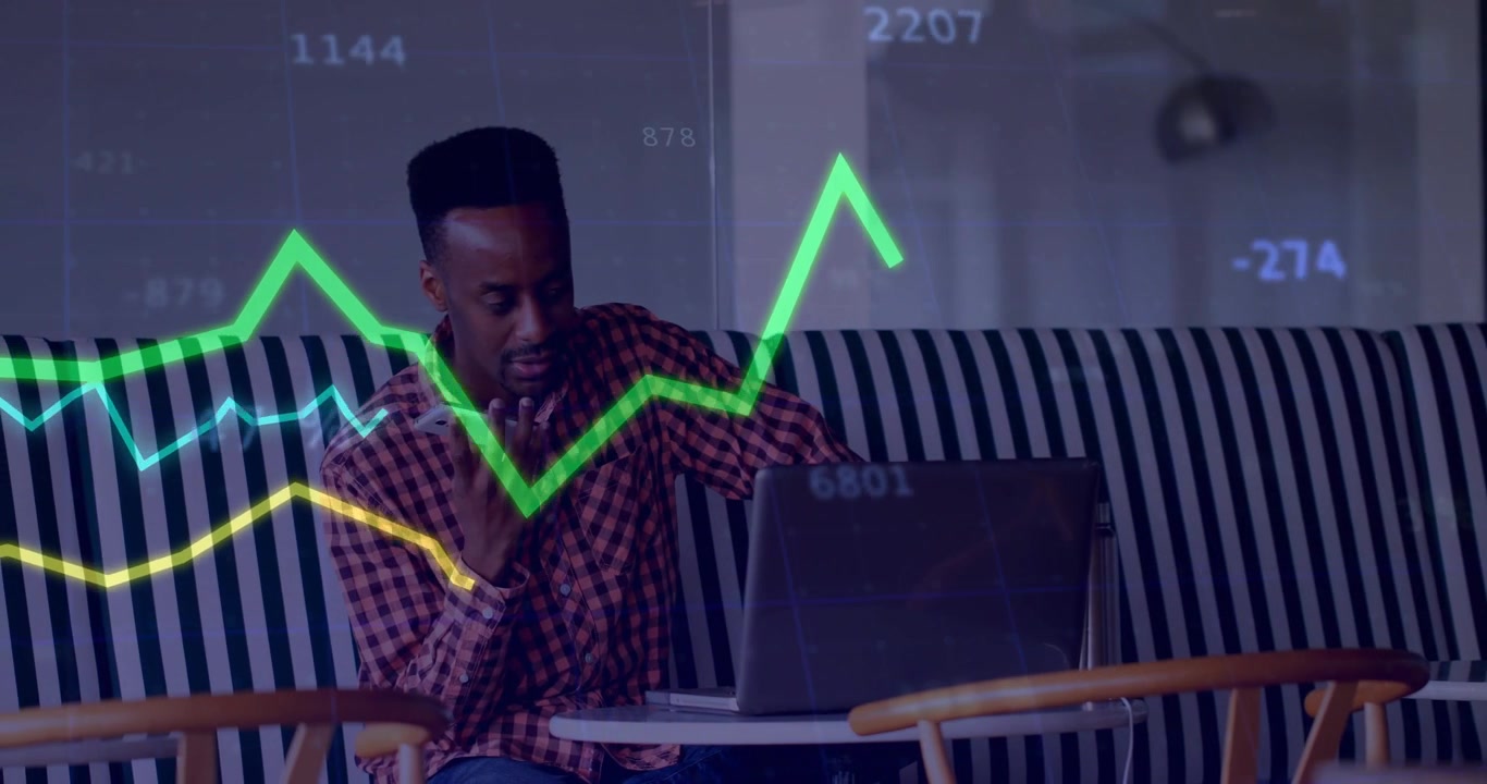 Man at café reaching for smartphone and calling while watching financial charts for trading