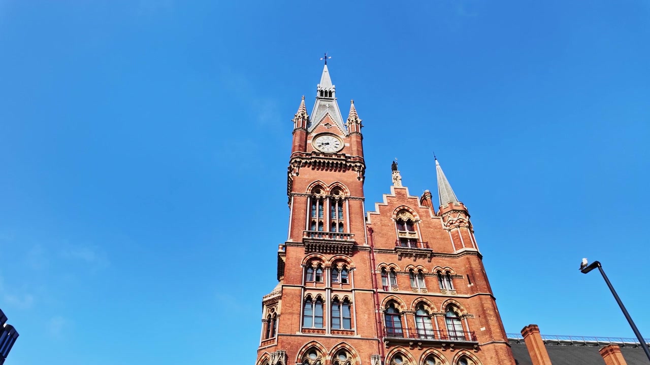 Beautiful low angle view of the clock tower at St Pancras international train station in London, England on a sunny summer day