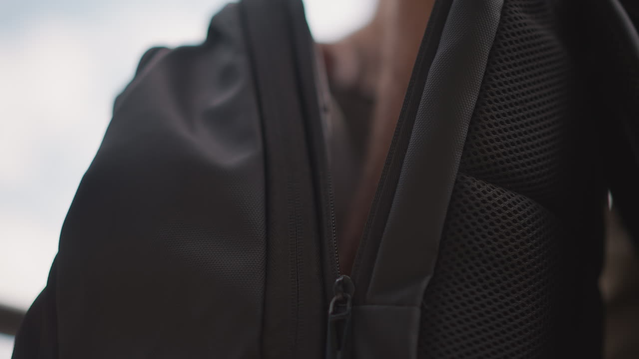 Man Organizing Gear, Closeup Of Man Arranging Equipment Outdoors, Individual Preparing Gear In Park Under Cloudy Sky, Gentle Motion Of Man Organizing Supplies In Natural Park Setting