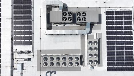 rooftop view of a commercial building with air conditioning units and solar panels