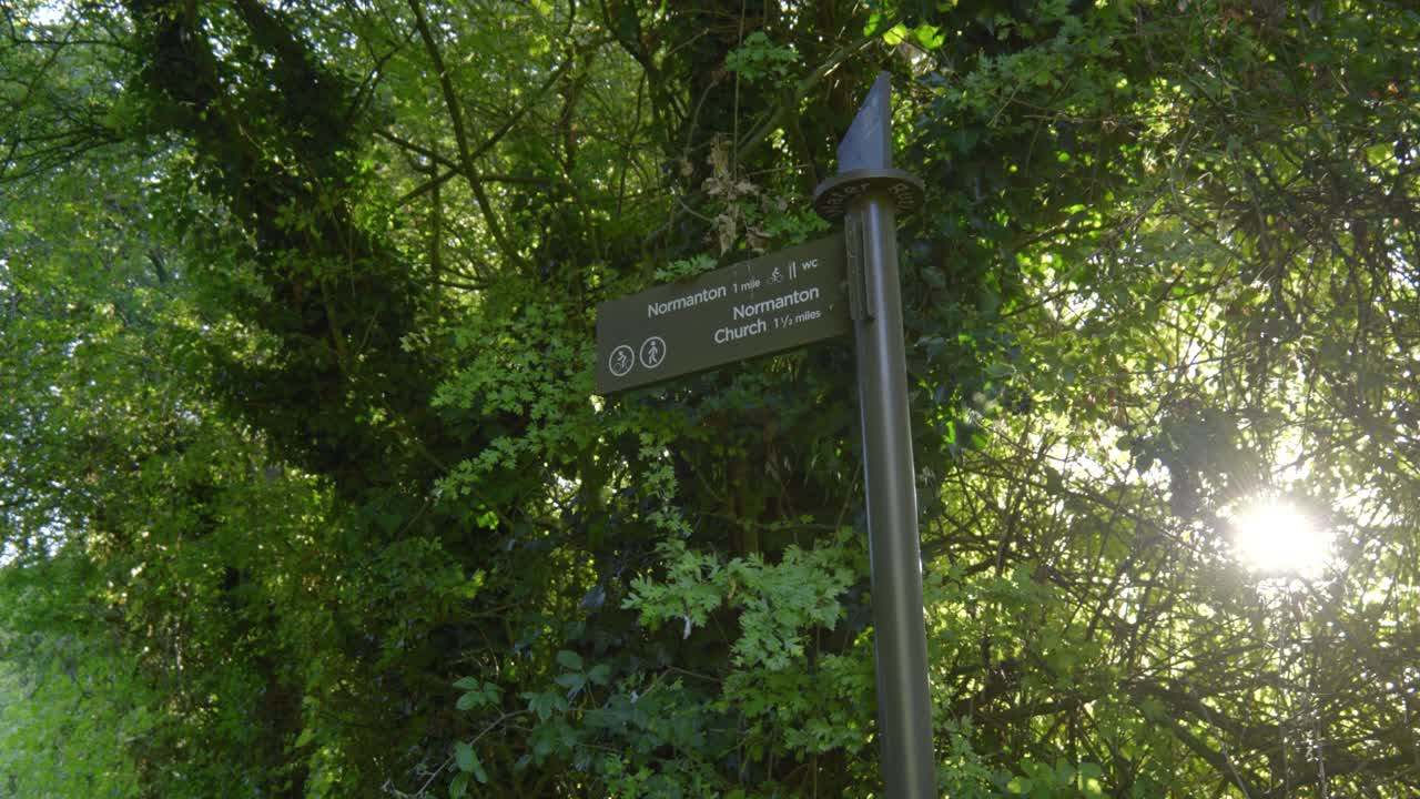 Signpost at sunny Rutland Water, UK, evokes calm nature exploration vibes