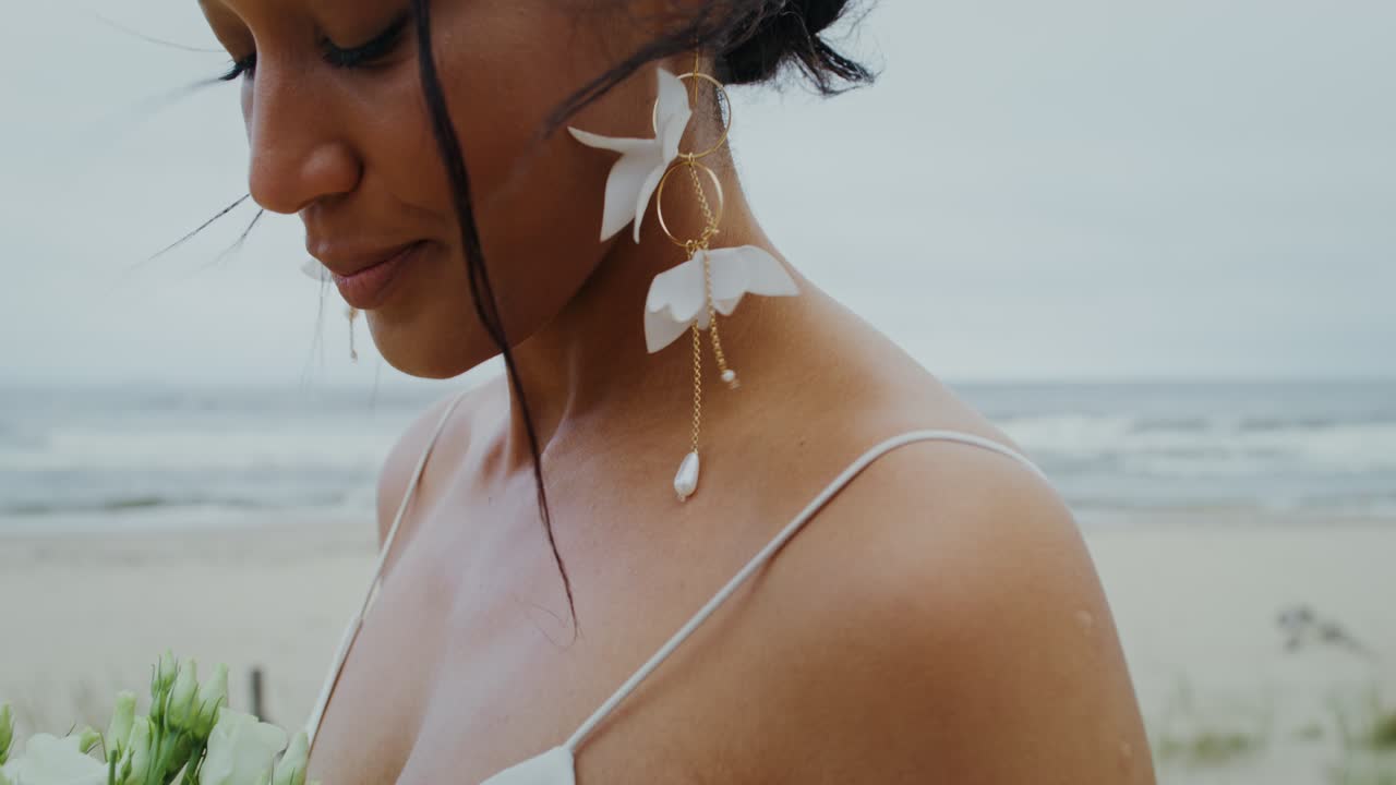 Bride with white flowers on the beach