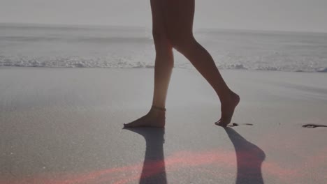 Animación-De-Puntos-De-Luz-Sobre-Una-Mujer-Caucásica-Caminando-Por-La-Playa