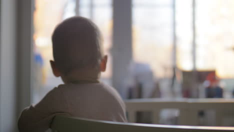 niño lindo con grandes ojos azules de pie en la cuna