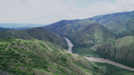 an aerial perspective showcasing a river flowing through a mountainous terrain with some clouds