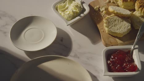 studio shot of person with traditional british afternoon tea with scones cream and jam 3