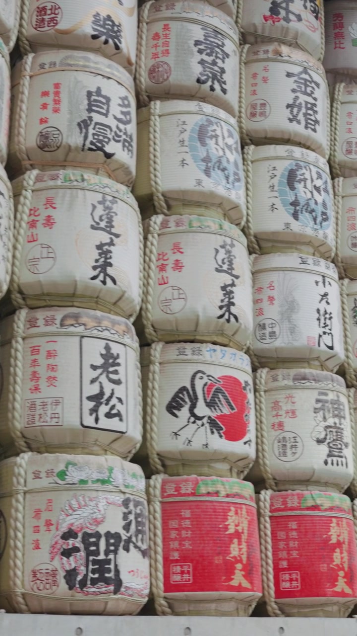 Vertical rows of beautifully decorated sake barrels create a colorful cultural landmark at Meiji Jingu Shrine, one of Tokyo's most visited historic destinations.