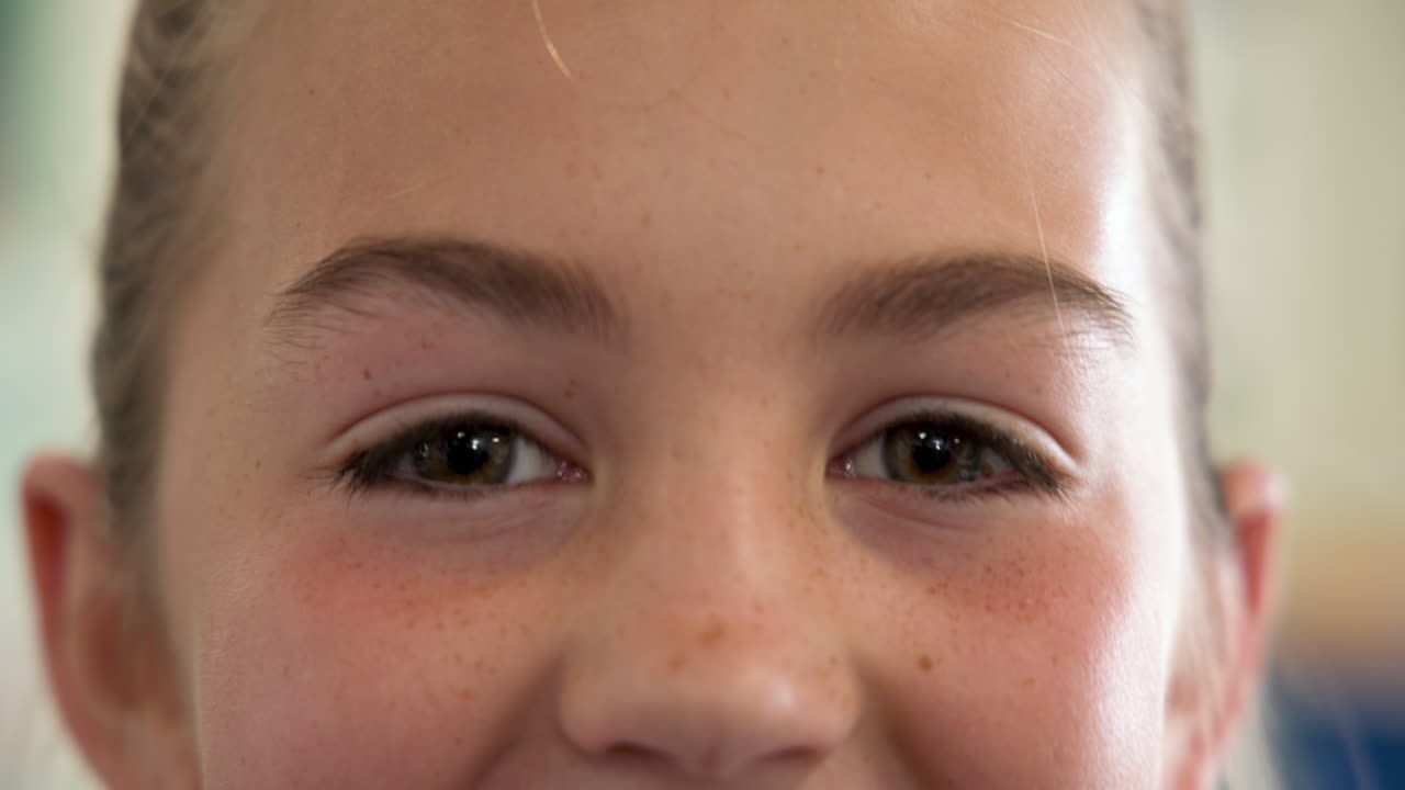 Close-up of girl's eyes looking upward, expressing curiosity and wonder, at school