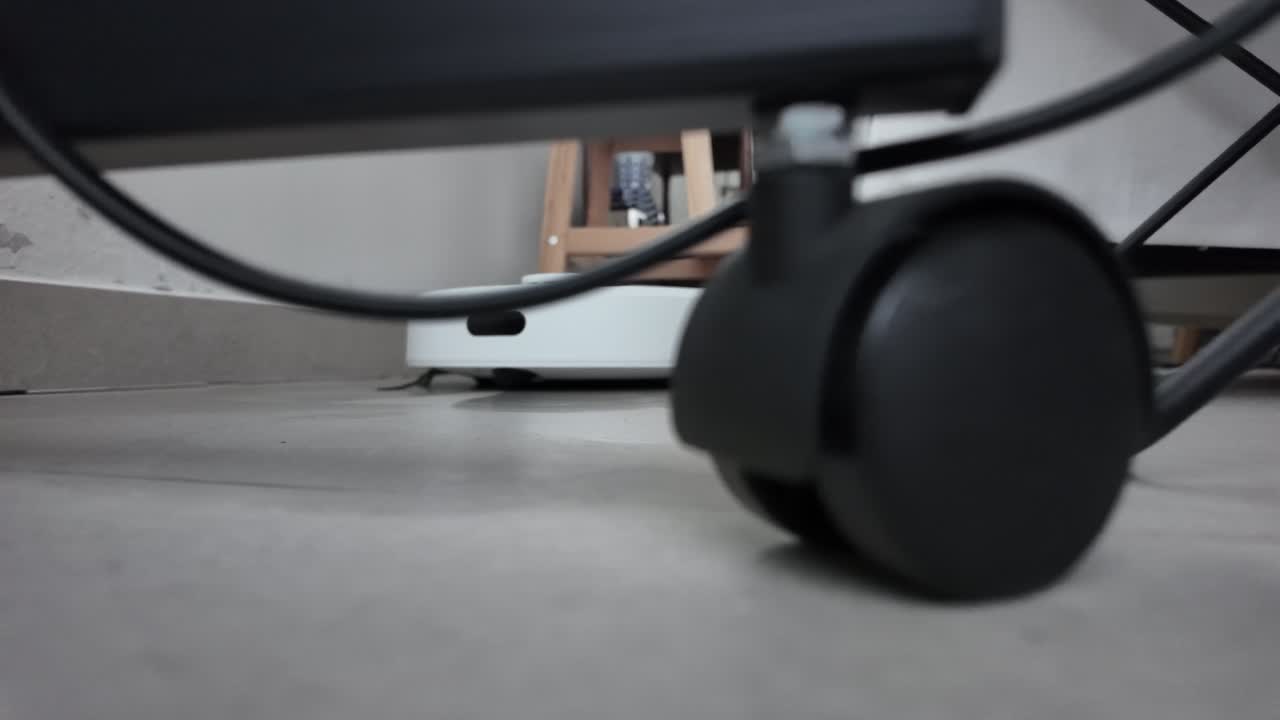 Robotic mop moving across a smooth indoor floor under furniture
