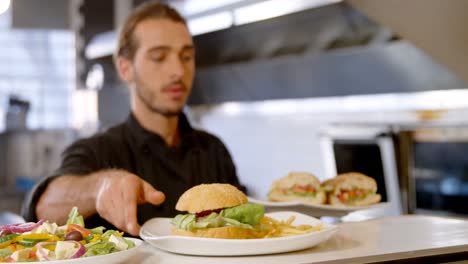 chef manteniendo platos de hamburguesas en la estación de pedidos 4k