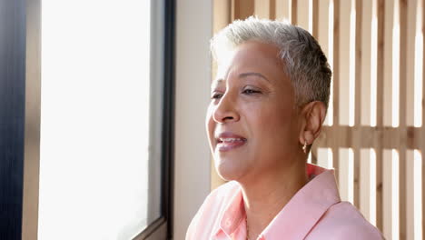 smiling senior woman with short hair enjoying peaceful moment by window