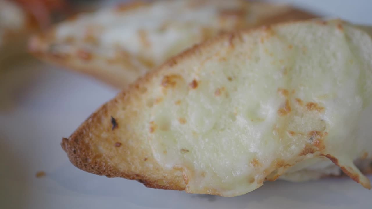 Close-up of golden brown cheesy garlic bread