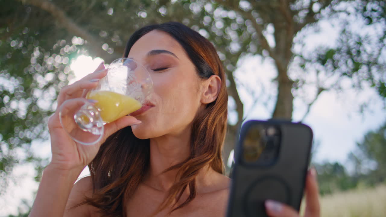 Smiling woman answering message smartphone resting on rural nature alone closeup