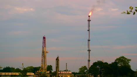 Flame-From-Oil-Refinery-Tower-At-Sunset---Wide-Shot