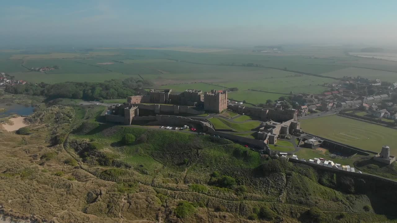 Ripresa aerea che gira intorno al Castello di Bamburgh nel Northumberland.