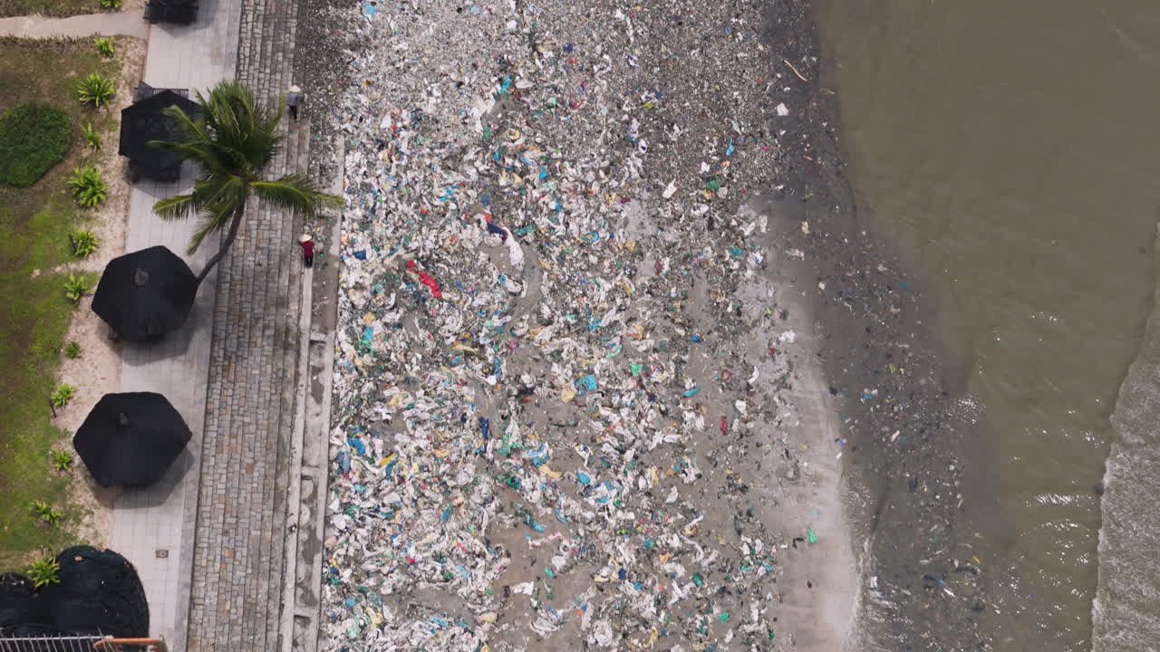 la gente limpiando la exótica playa de ham tien cubierta de montones de basura, vista de arriba hacia abajo