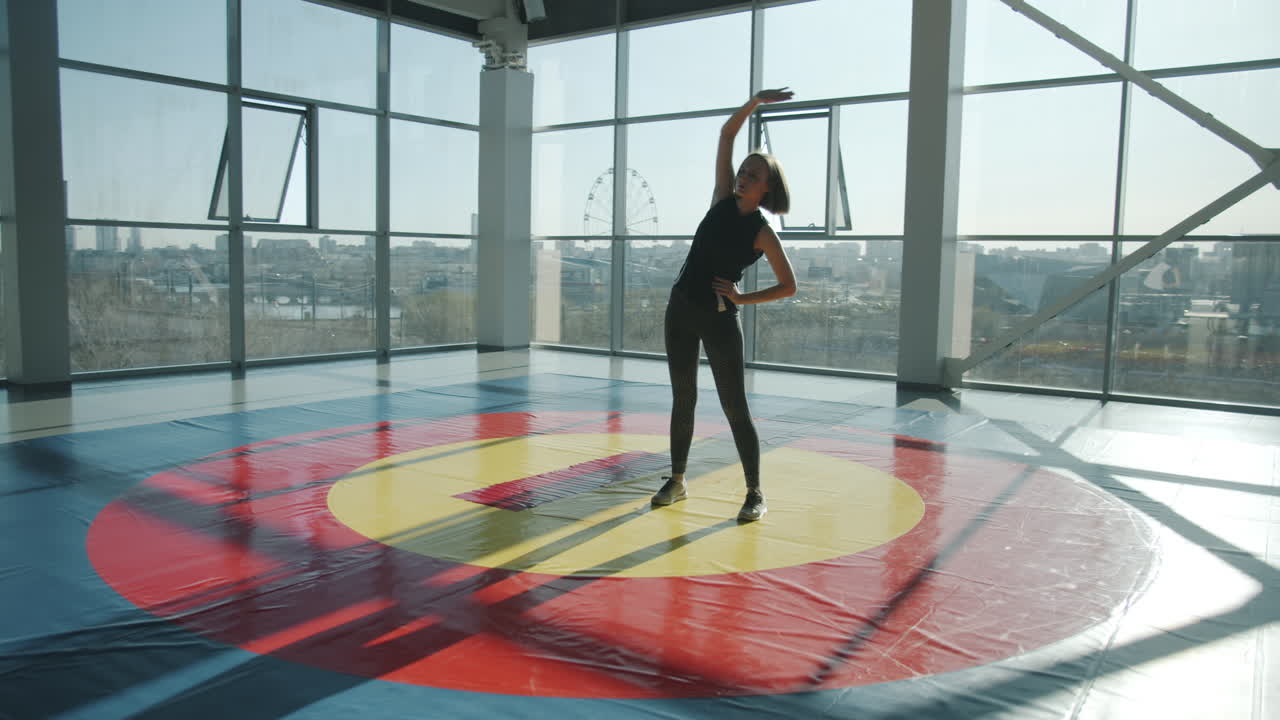 mujer estirándose en un gimnasio