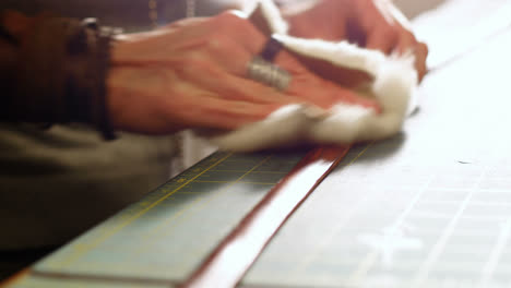 mid-section of craftswoman preparing leather belt