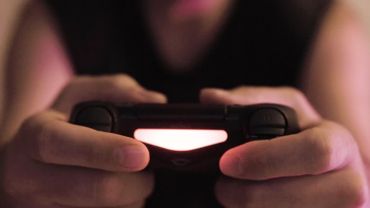 persona che gioca a videogiochi con un controller di gioco, console playstation, dipendenza da videogiochi, problemi di salute