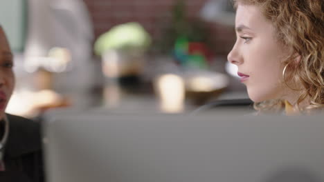 hermosa mujer de negocios pelirroja escribiendo usando una computadora útil líder de equipo compartiendo ideas señalando a la pantalla entrenamiento colega afroamericano discutiendo la solución del proyecto en una oficina diversa