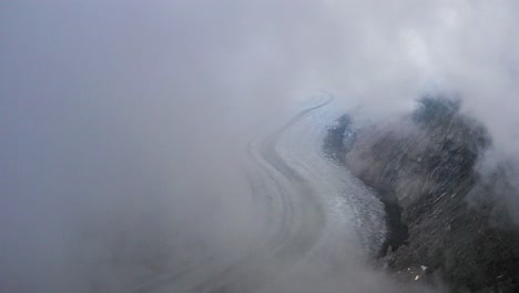 aerial reveals view of aletsch glacier covered in fog, switzerland
