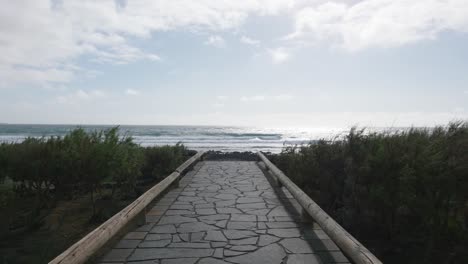 pov view of a path leading to a beach during a windy day in el médano, tenerife canary islands, spain.