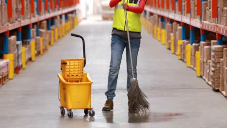 female warehouse worker moping floor