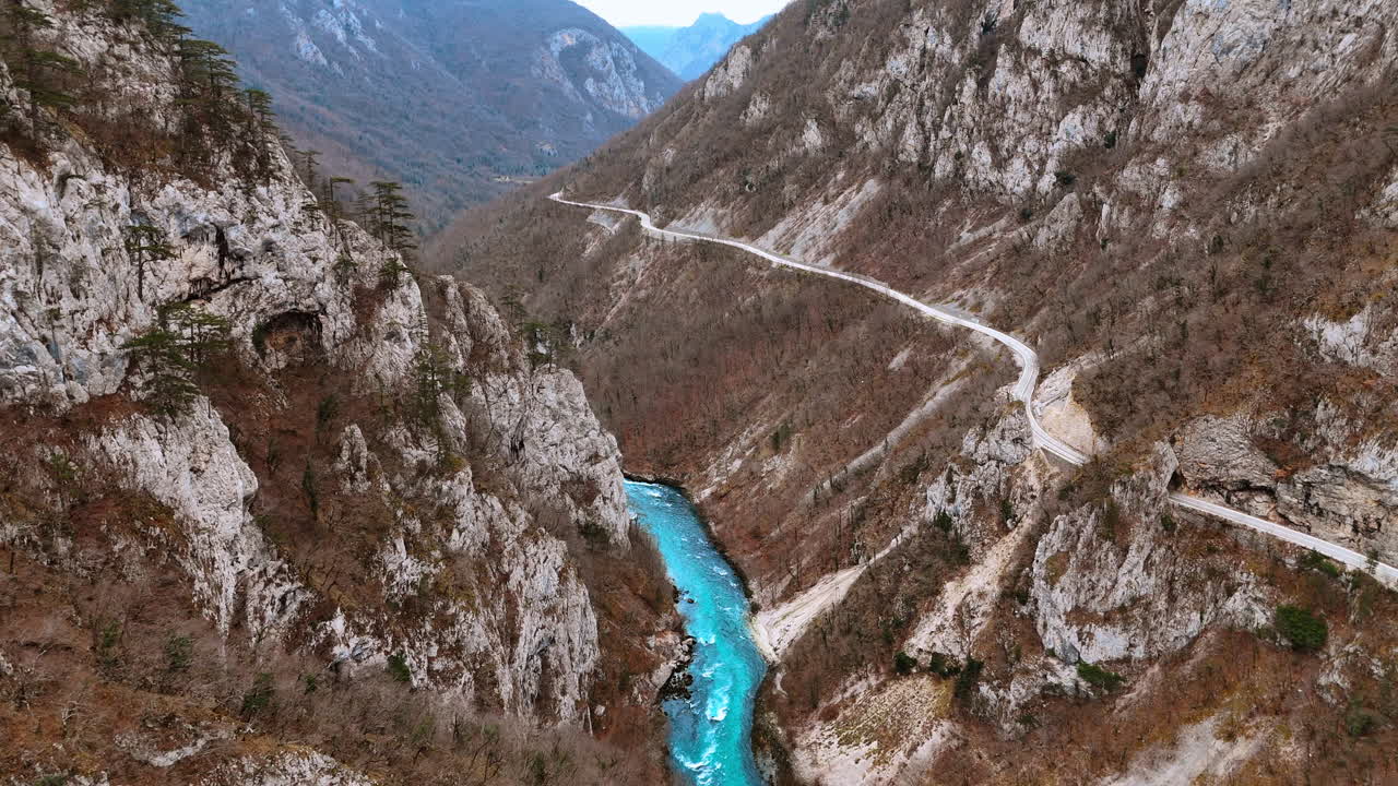 Vista aerea di una strada di montagna tortuosa sopra il fiume Piva. Scatto dall'alto di una strada asfaltata a serpentina sul fianco della scogliera accanto al fiume turchese nel canyon di Piva, Montenegro