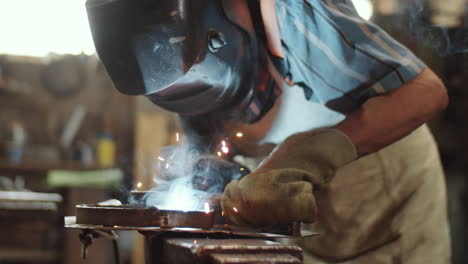 worker welding iron detail in smithy