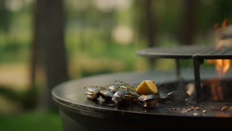 unknown guy taking seafood from grade. man hands picking up mussels from grill
