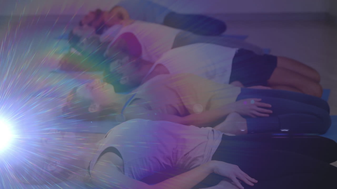 요가 수업에서 휴식을 취하는 사람들 위에 움직이는 반이는 빛의 애니메이션