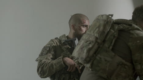 tired soldiers walking down hall of hostile building