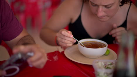 slow motion close up of a latin woman stirring his barbacoa broth with a spoon and giving it a sip in a restaurant in mexico