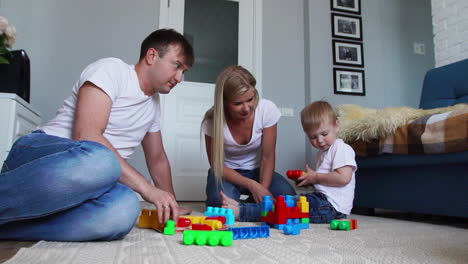 Glückliche-Familie,-Vater,-Mutter-Und-Baby-2-Jahre,-Die-In-Ihrem-Hellen-Wohnzimmer-Lego-Spielen.-Zeitlupenaufnahmen-Einer-Glücklichen-Familie