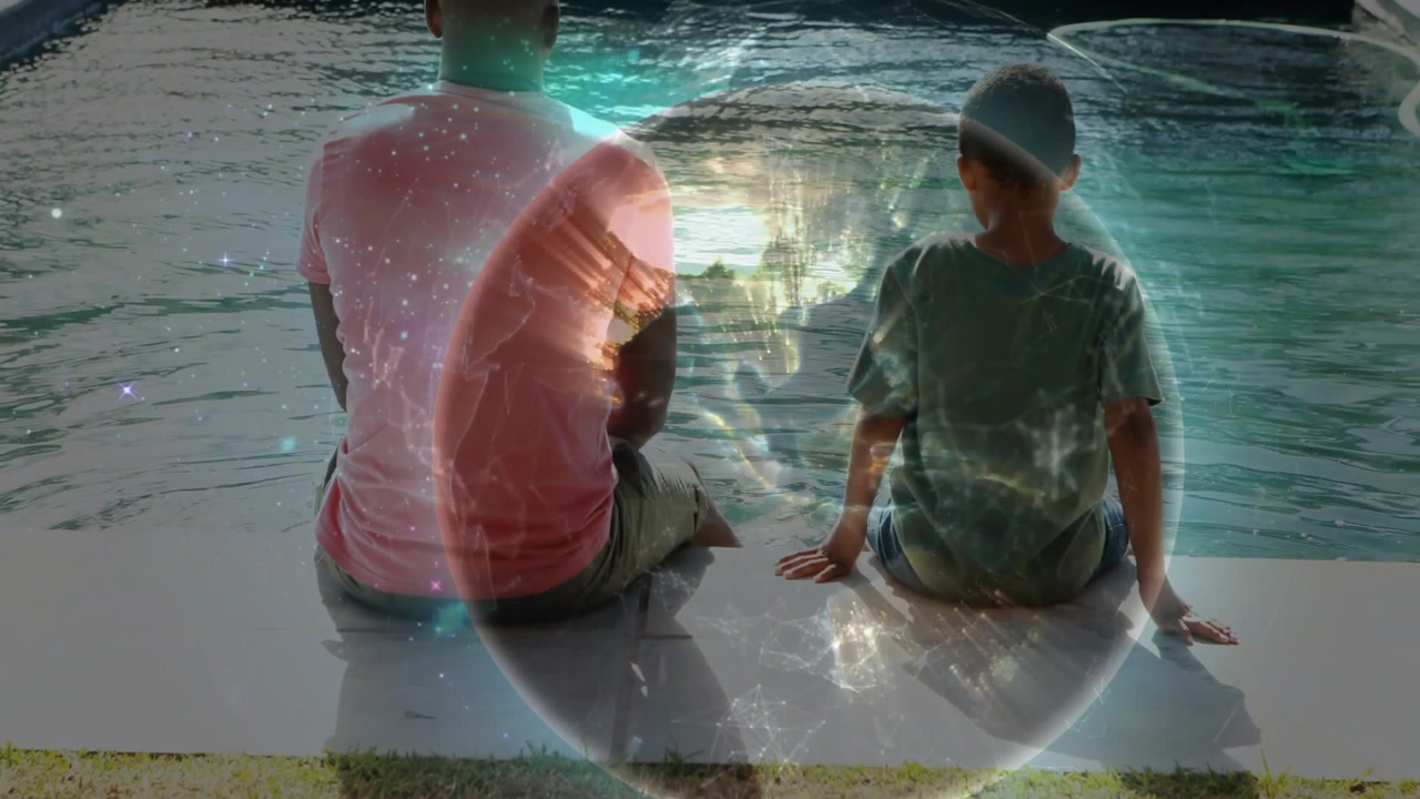 Vertical video: Man and boy sitting pool, globe emerging from noise lighting pool, bonding via tech