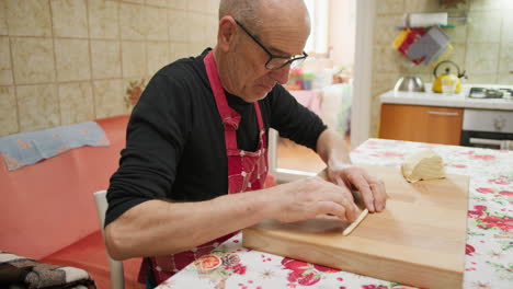 bald man prepares homemade pasta for lunch