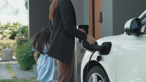 estilo de vida progresivo de madre e hija con coche eléctrico y estación de carga.