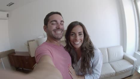 young couple having a video call via smartphone, smiling and talking about new house