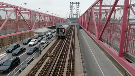 new york subway train passes over williamsburg bridge