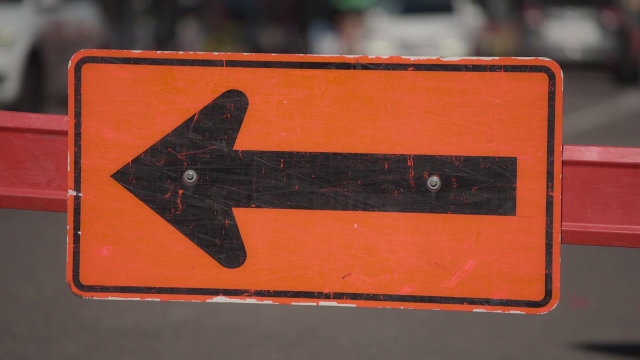 Señal de tráfico de obras con dirección a la izquierda