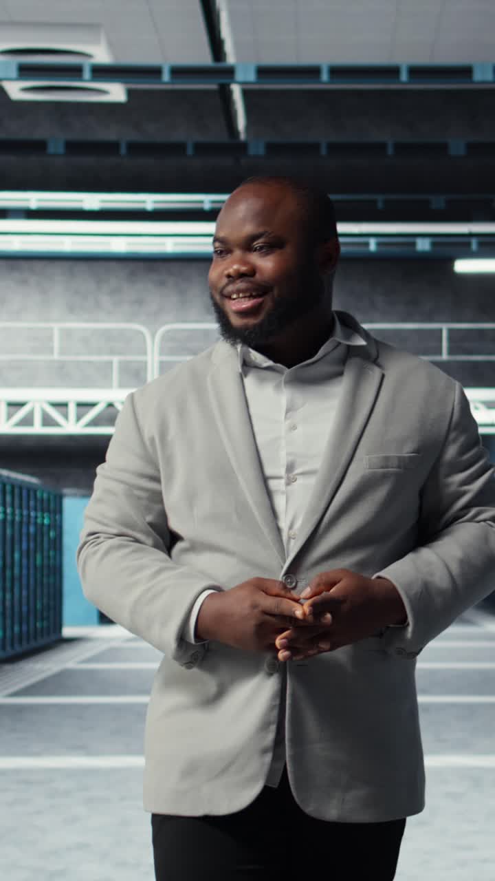 Vertical video Cheerful admin walking in data center, checking gear for system stability