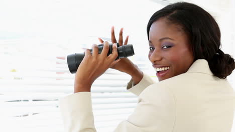 Businesswoman-looking-through-blinds-with-binoculars