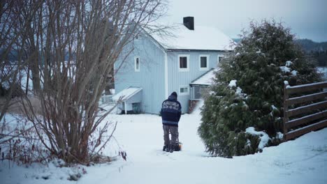 hombre limpiando el camino usando soplador de nieve durante el invierno