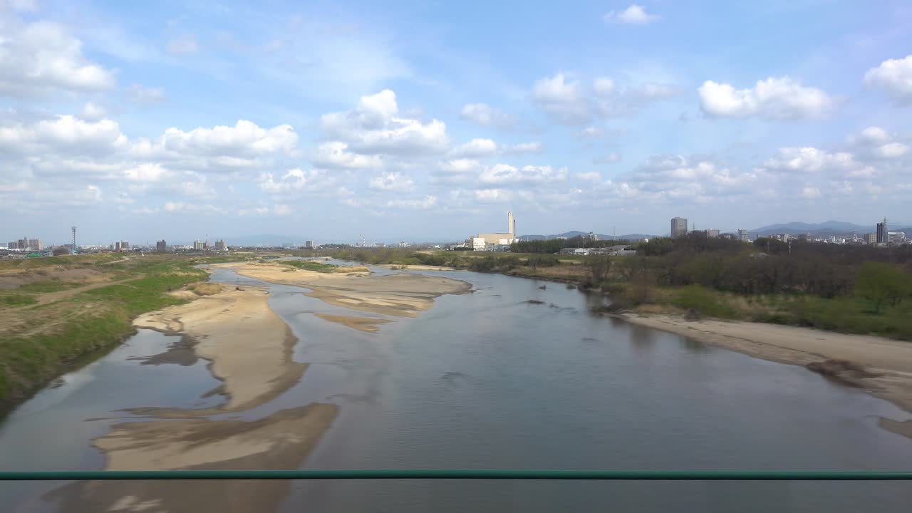 일본 기차 창 앞을 지나가는 넓은 강이 있는 교외 지역