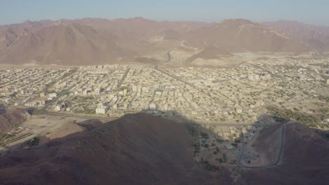 Bewundern-Sie-Die-Stadt-Khorfakkan-Von-Oben-Mit-Der-Atemberaubenden-Luftaufnahme-Einer-Dolly-Back-Drohne