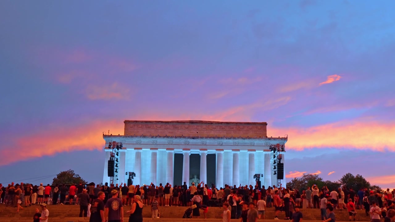 Washington, USA, 13 June 2026: Crowds on the steps of Lincoln Memorial at sunset. Illuminated columns with vivid orange and purple clouds above.