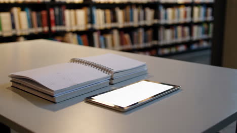 books and tablet on a library desk