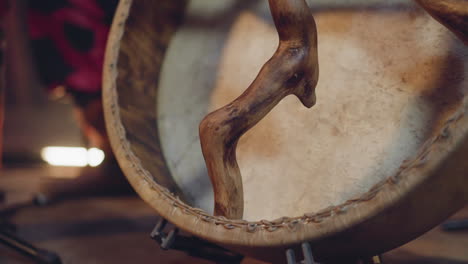 musician with old shamanic drum with handles of curvy sticks