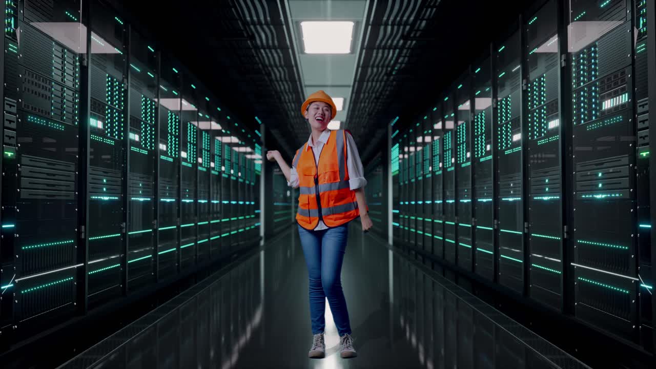 Full Body Of Asian Female Engineer With Safety Helmet Screaming Goal And Dancing Celebrating in Server Room Data Center