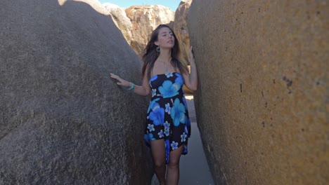 Beautiful-Woman-In-Floral-Dress-Walking-Between-Huge-Rocks-At-Horseshoe-Bay-In-Bowen,-Queensland